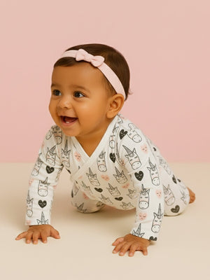 Picture of a baby wearing jabla style romper with unicorn and heart designs from the mom store