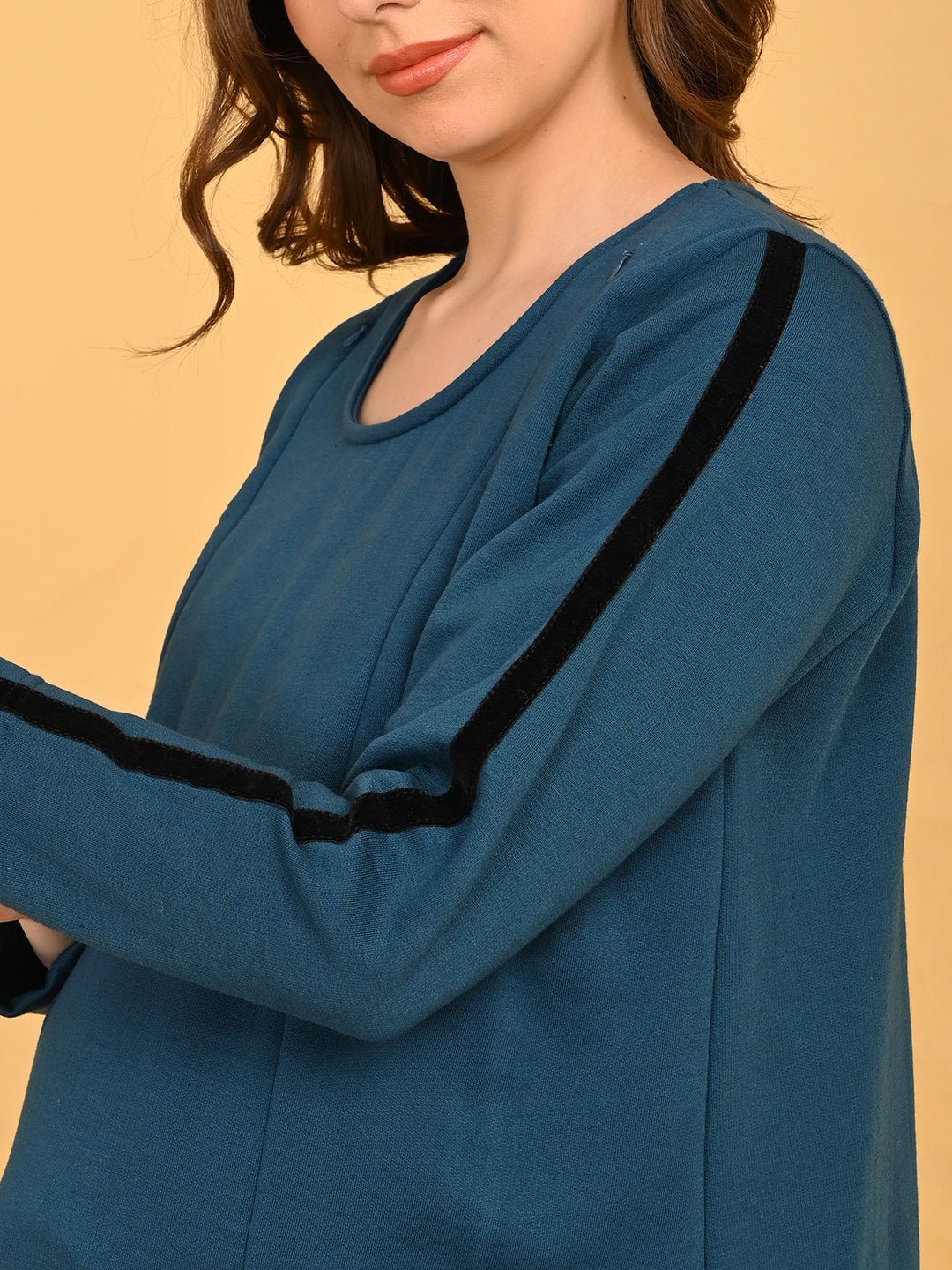 Close-up of Keepin’ It Teal maternity top sleeve featuring black contrast stripe detail.