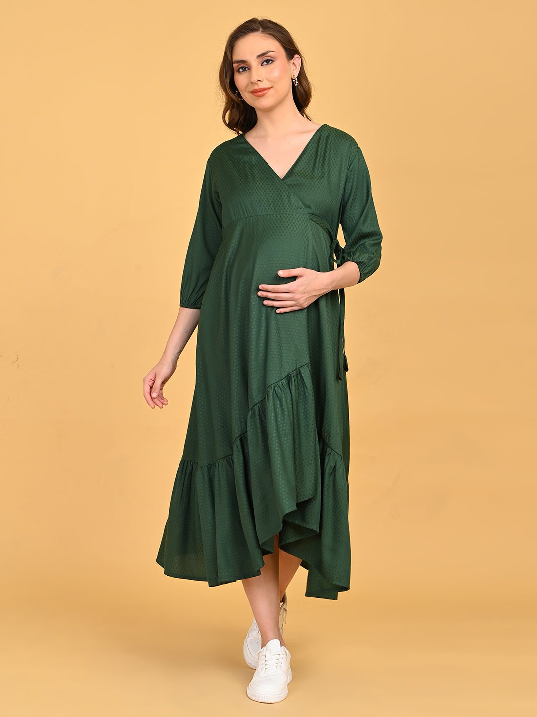 Leaf Me Breathless Maternity Wrap Dress full-length front view styled with white sneakers, showcasing asymmetrical ruffle hem and wrap silhouette.