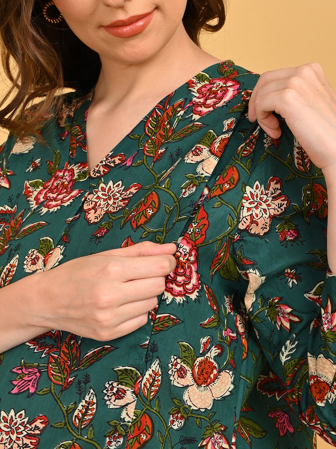 Close-up of concealed side zipper on green floral maternity dress for easy nursing access.