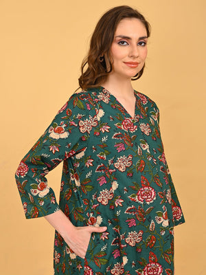 Side view of pregnant model in green floral maternity dress showing relaxed fit and side pocket detail.