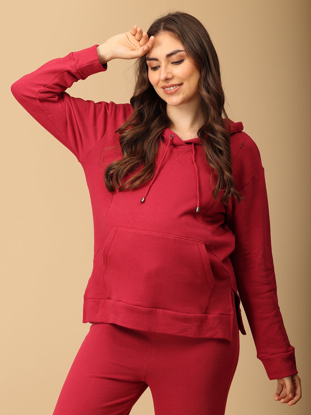 Woman wearing magenta maternity hoodie and pajama set from The Mom Store, designed for nursing comfort