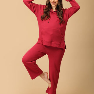 Woman wearing magenta maternity hoodie and pajama set from The Mom Store, designed for nursing comfort