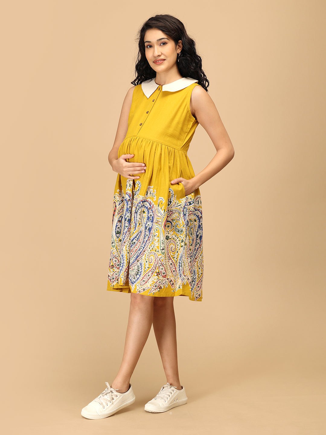 Side pose of The Mom Store marigold maternity and nursing dress with vibrant paisley print.