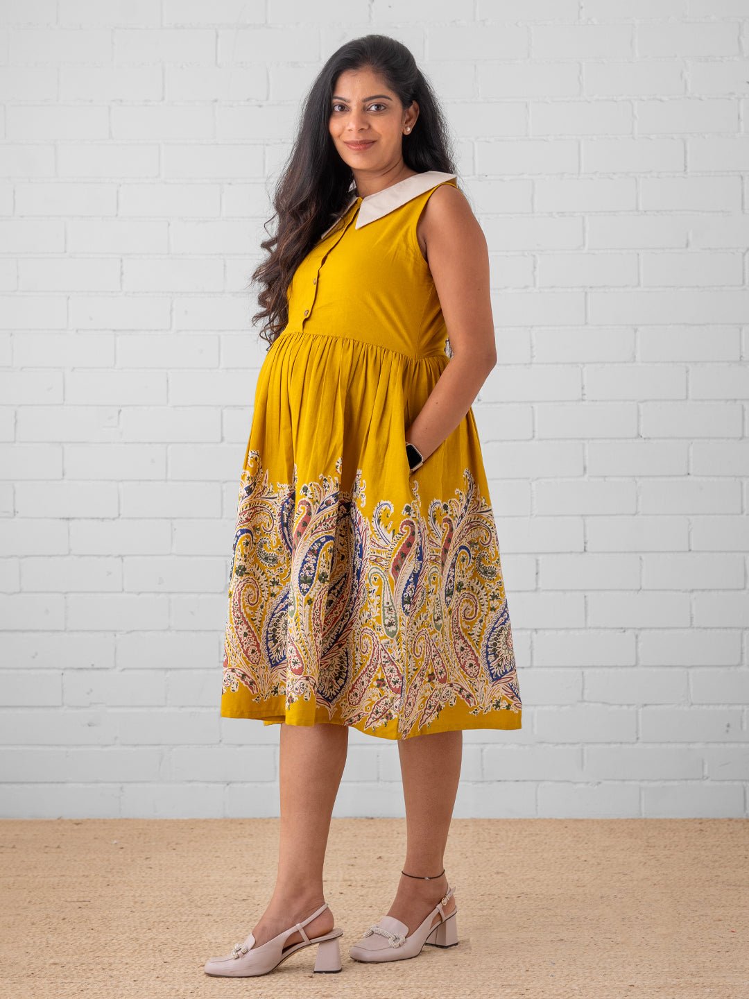 Pregnant woman wearing yellow Marigold Mirage maternity dress with paisley print – The Mom Store.