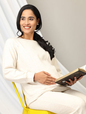 Close up of Model sitting on a chair reading a book wearing Marshmallow Maternity and Feeding Pajama Loungewear Set from the mom store