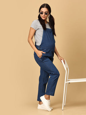 Relaxed pose of pregnant woman in The Mom Store blue Denim Maternity Dungaree with Side Buttons and sunglasses