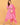 Model styling pink maternity kurta set with dupatta and beige handbag for festive wear.