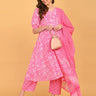Model styling pink maternity kurta set with dupatta and beige handbag for festive wear.