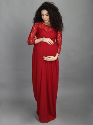 A visibly pregnant model wearing mulberry coloured, maternity maxi dress from The Mom Store, touching her bump.