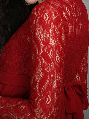 close up of lace sleeve of mulberry coloured, maternity maxi dress from The Mom Store, touching her bump.