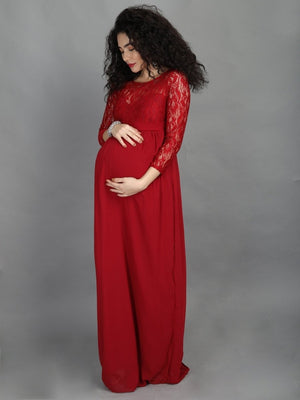 side profile of pregnant model wearing mulberry coloured, maternity maxi dress from The Mom Store, touching her bump.