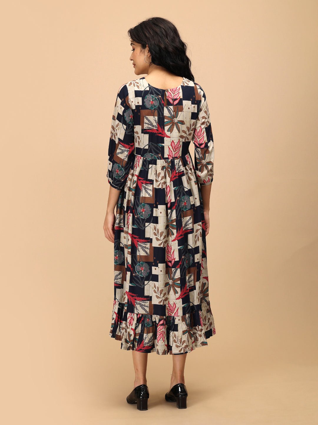 Back view of The Mom Store Muted Muse maternity dress with patch-print floral pattern and ruffle hem.