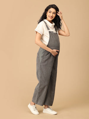 Side pose showing The Mom Store olive corduroy maternity dungaree with wide-leg comfort.