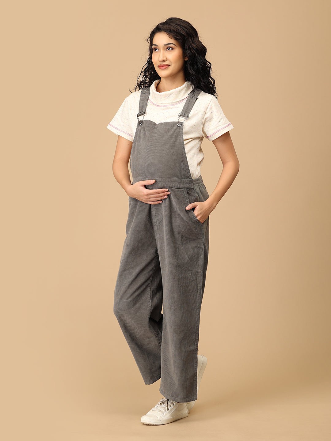 Side pose showing The Mom Store olive corduroy maternity dungaree with wide-leg comfort.
