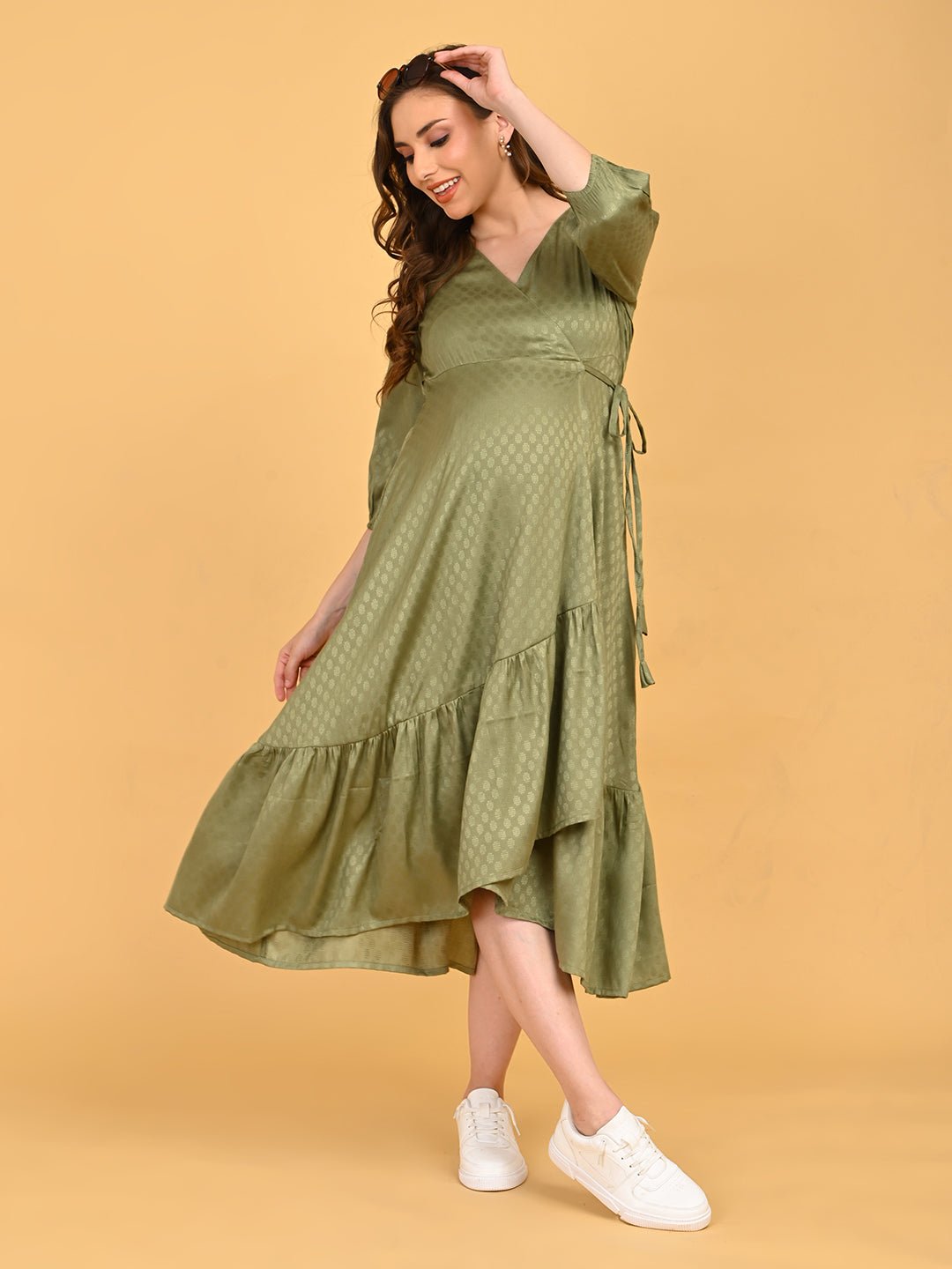 Olivious Maternity Wrap Dress full-length front view styled with white sneakers, showcasing asymmetrical ruffle hem and wrap silhouette.
