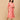 Model wearing a peach printed maternity and nursing dress layered with a matching open-front shacket, standing against a beige background.