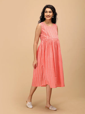 Angled view of peach printed maternity dress showing flowy silhouette and lightweight cotton fabric.