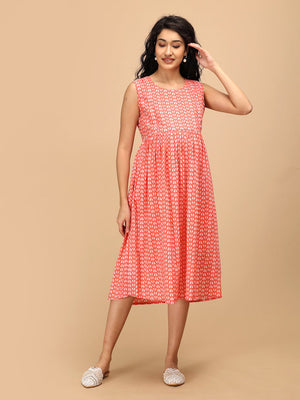 Sleeveless peach maternity and nursing dress with soft gathers under the bust for a comfortable pregnancy fit.