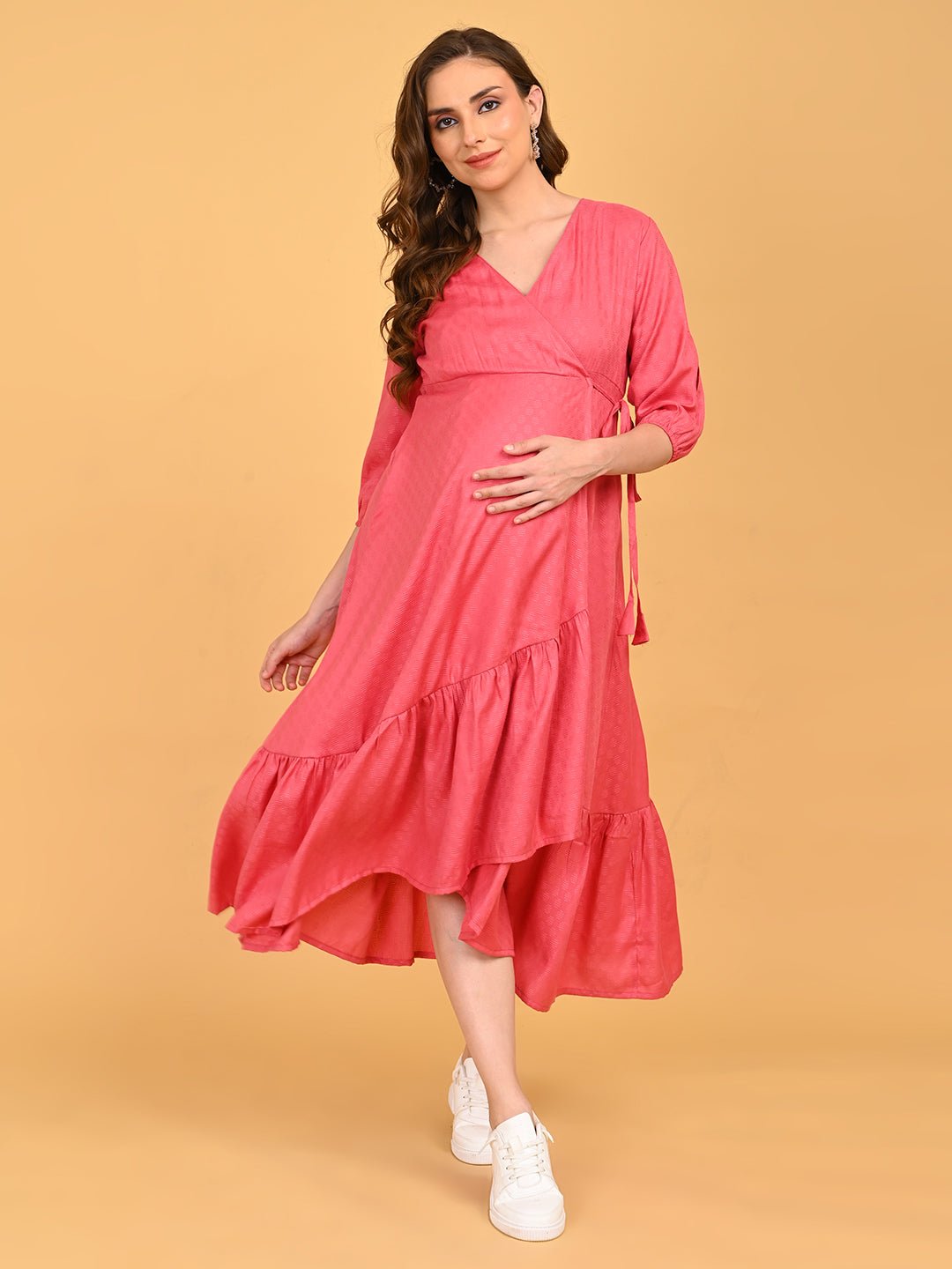 Pink to the Future Maternity Wrap Dress full-length front view styled with white sneakers, showcasing the asymmetrical ruffle hem.