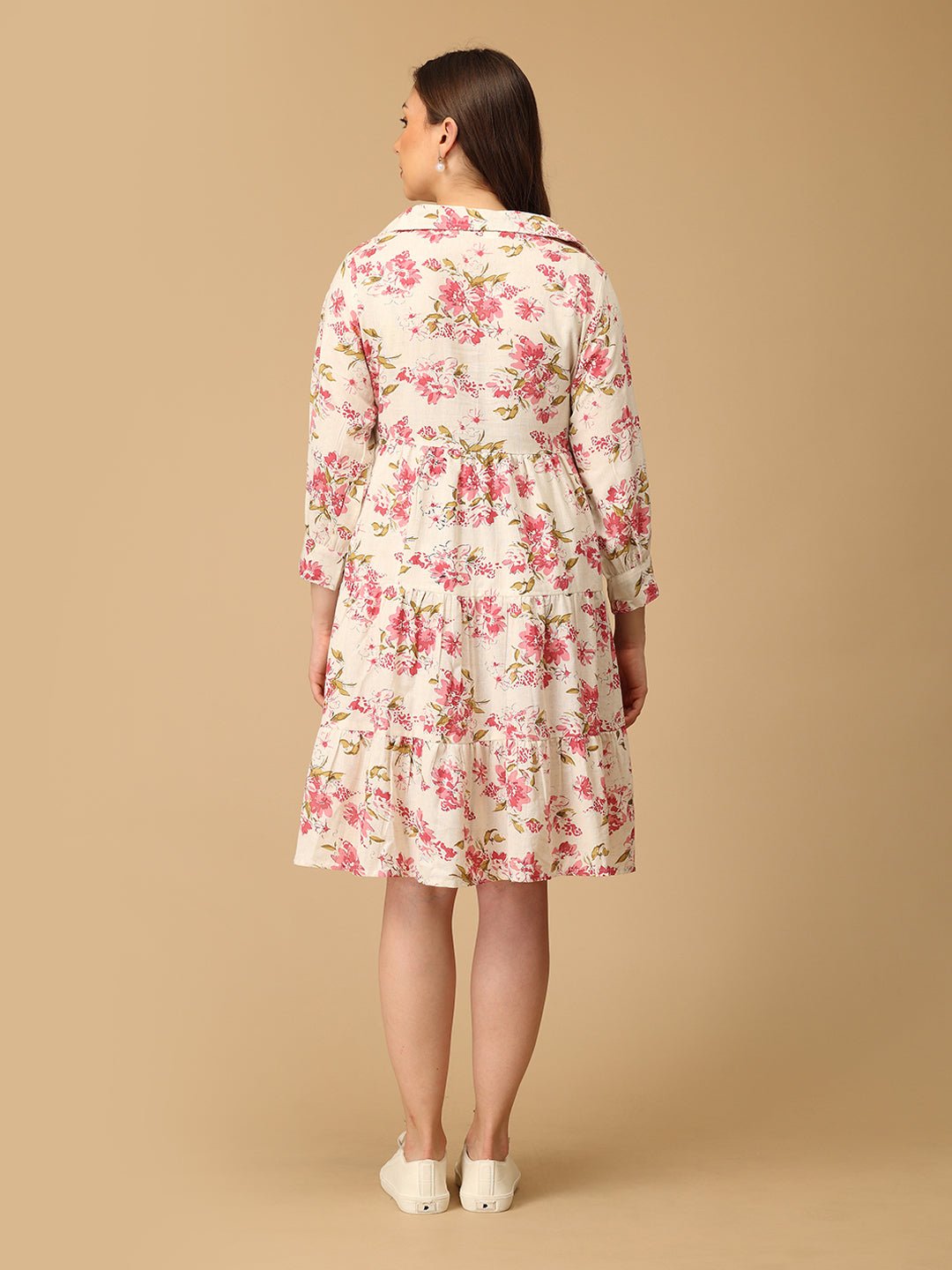Woman wearing a floral dress against a beige background