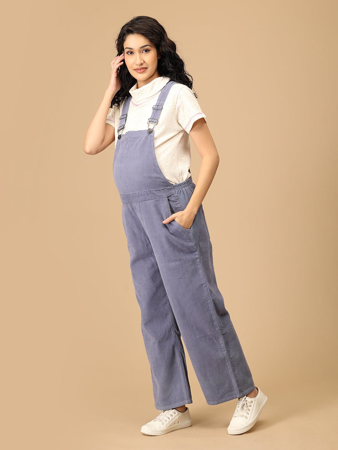Side pose showing The Mom Store powder blue corduroy maternity dungaree with relaxed wide-leg fit.