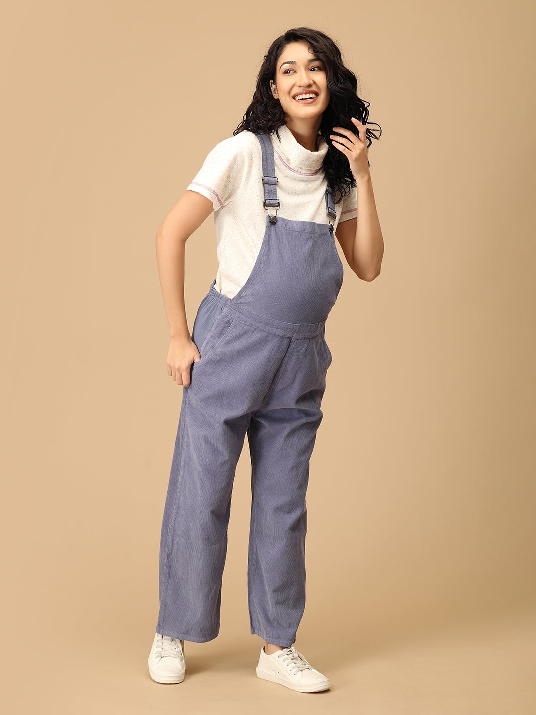 Smiling pregnant woman wearing The Mom Store powder blue corduroy maternity dungaree front pose.