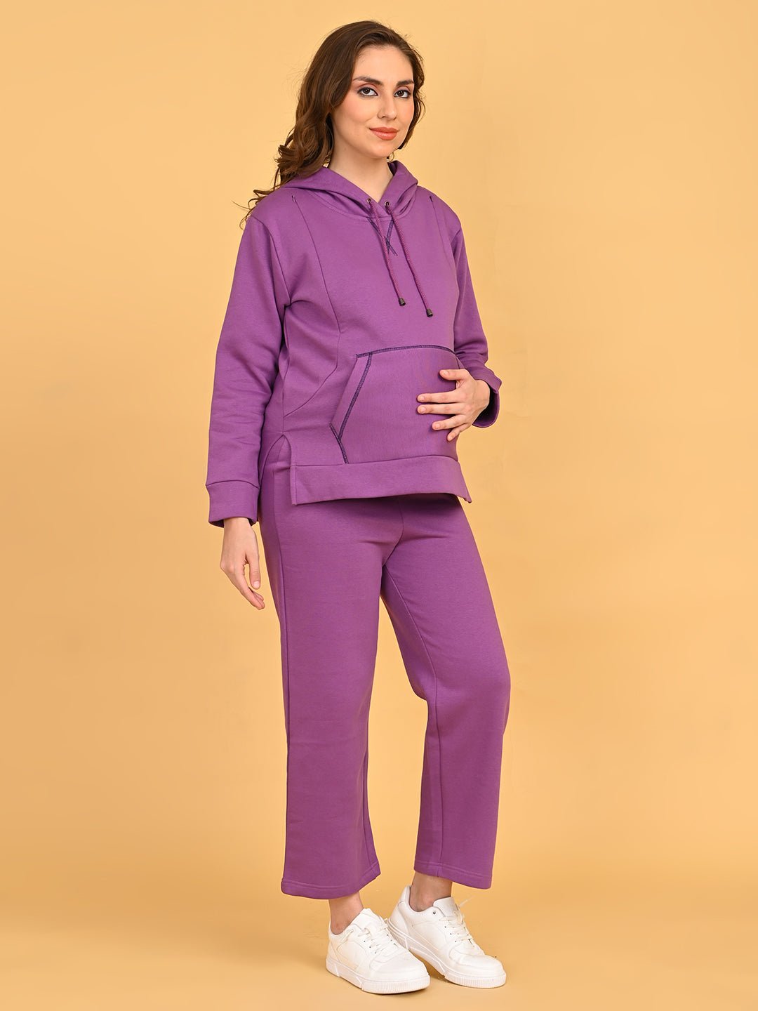 Pregnant model wearing Purple Frostbite maternity and nursing hoodie with matching lounge pants, gently holding baby bump.