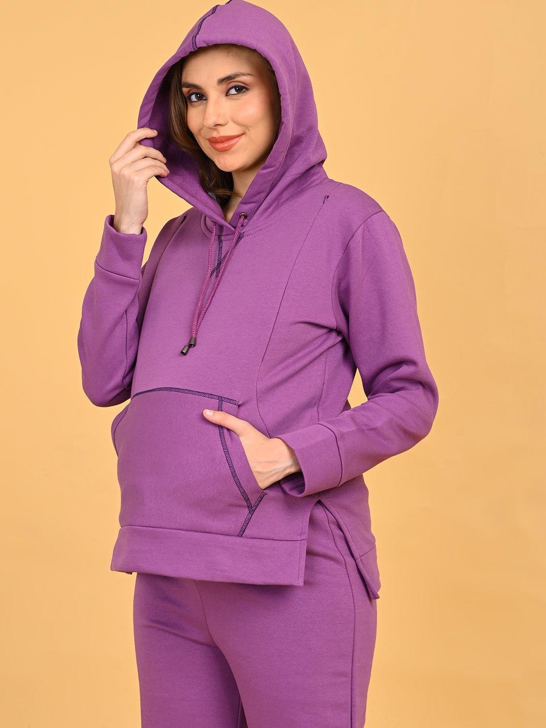 Model wearing Purple Frostbite maternity hoodie with hood up, hands in kangaroo pocket.