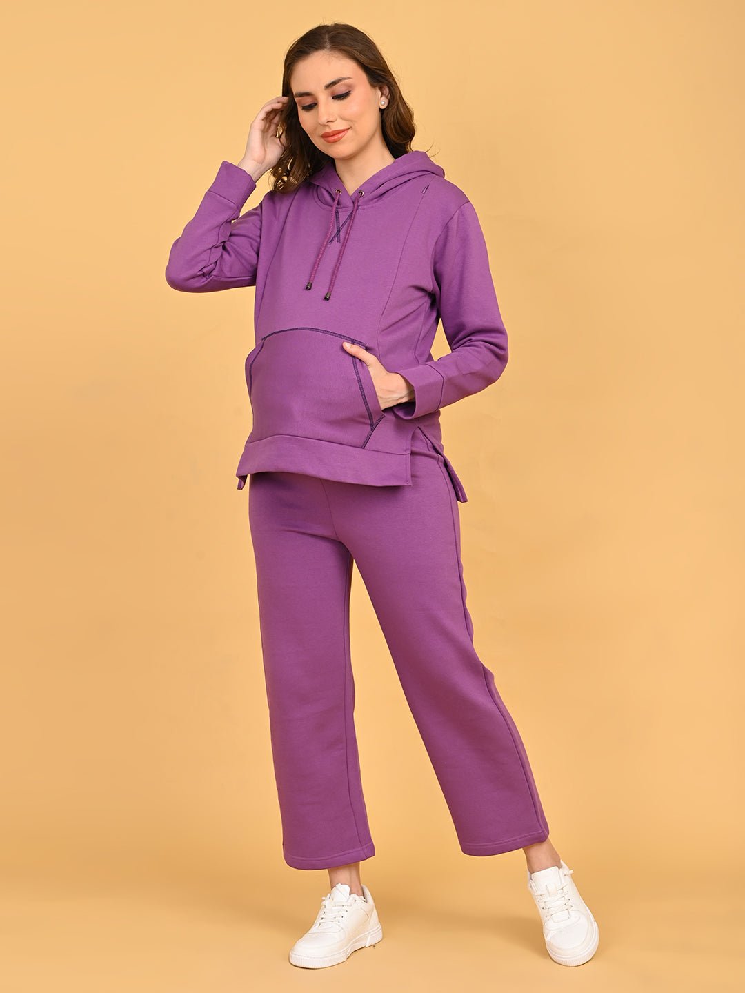 Pregnant model wearing Purple Frostbite maternity and nursing hoodie with matching lounge pants, gently holding baby bump.