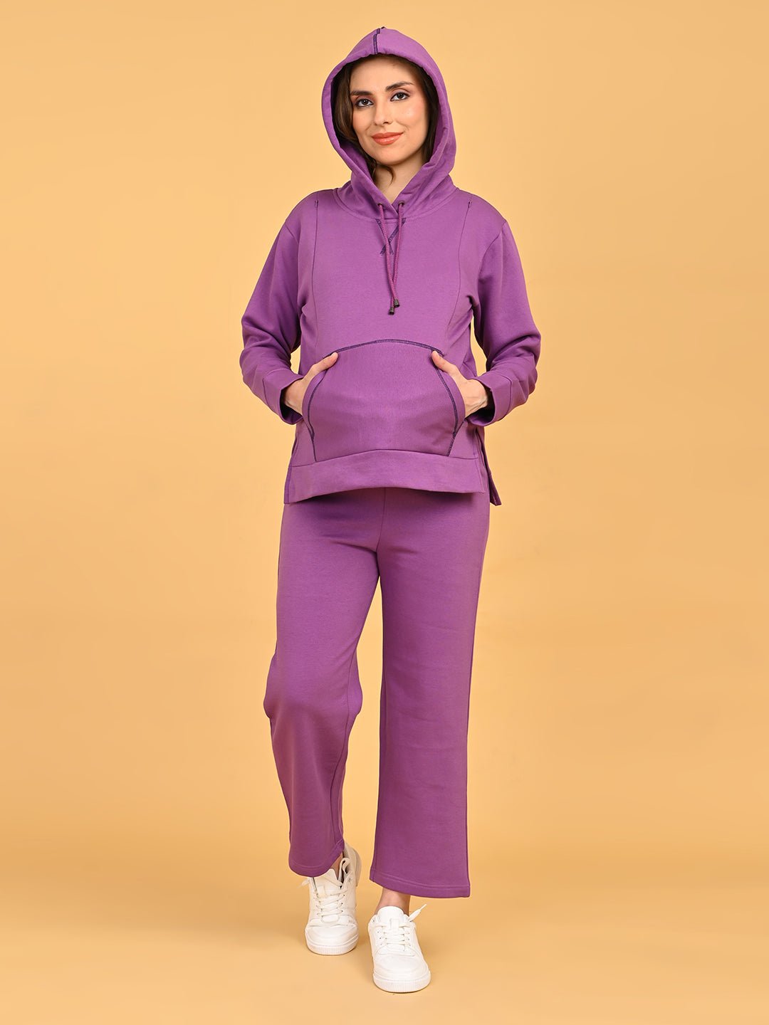 Model wearing Purple Frostbite maternity hoodie with hood up and matching pajama pants, hands in kangaroo pocket.