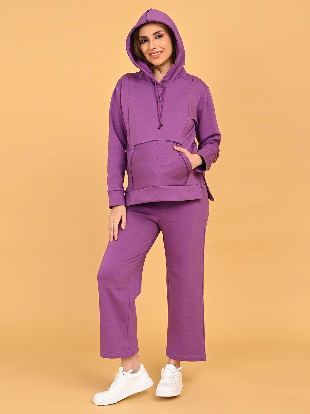 Model wearing Purple Frostbite maternity hoodie with hood up and matching pajama pants, hands in kangaroo pocket.