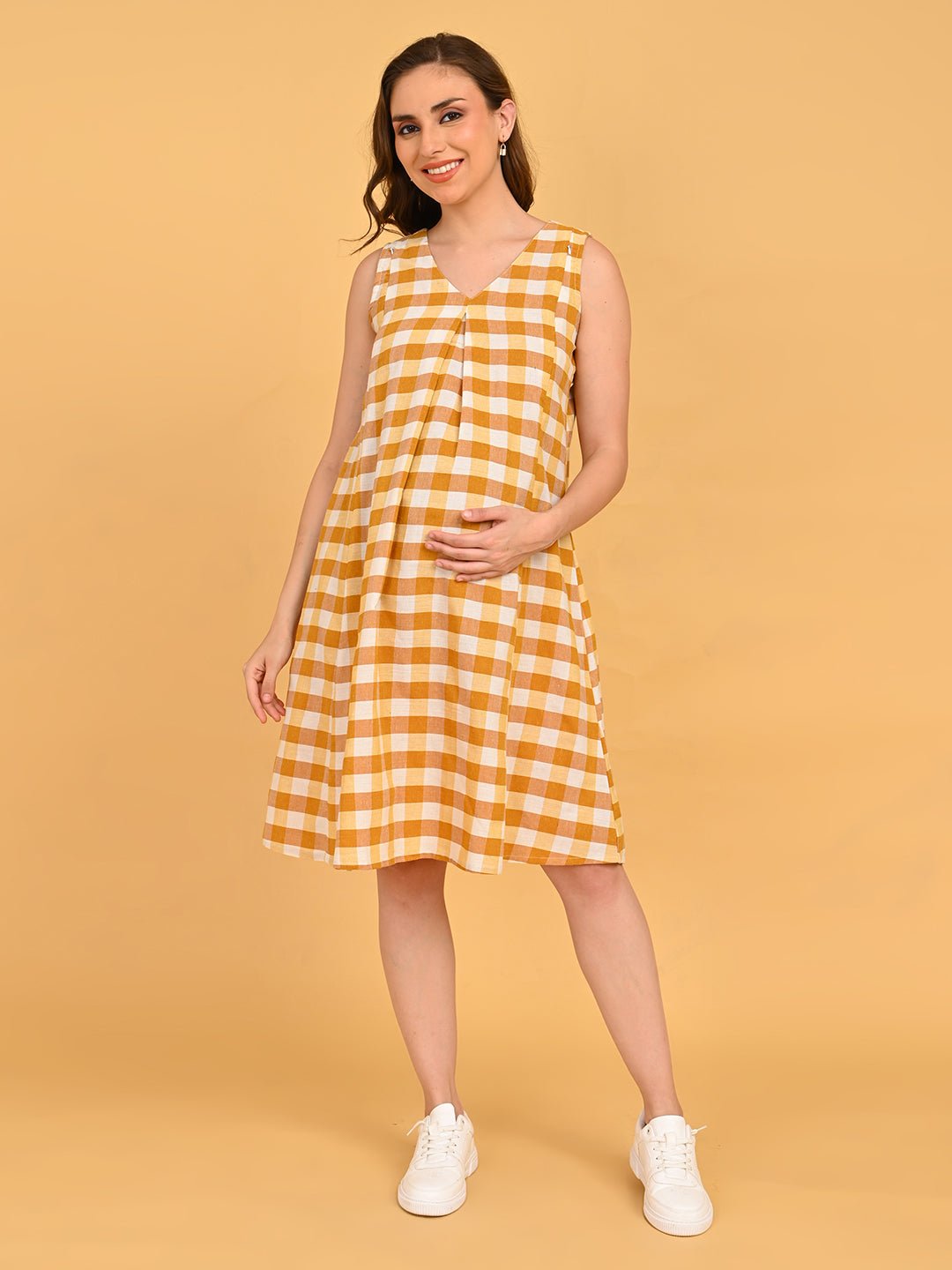 Quiet Grid Maternity and Nursing Shacket Dress front three-quarter pose with model holding baby bump in yellow check maternity dress.
