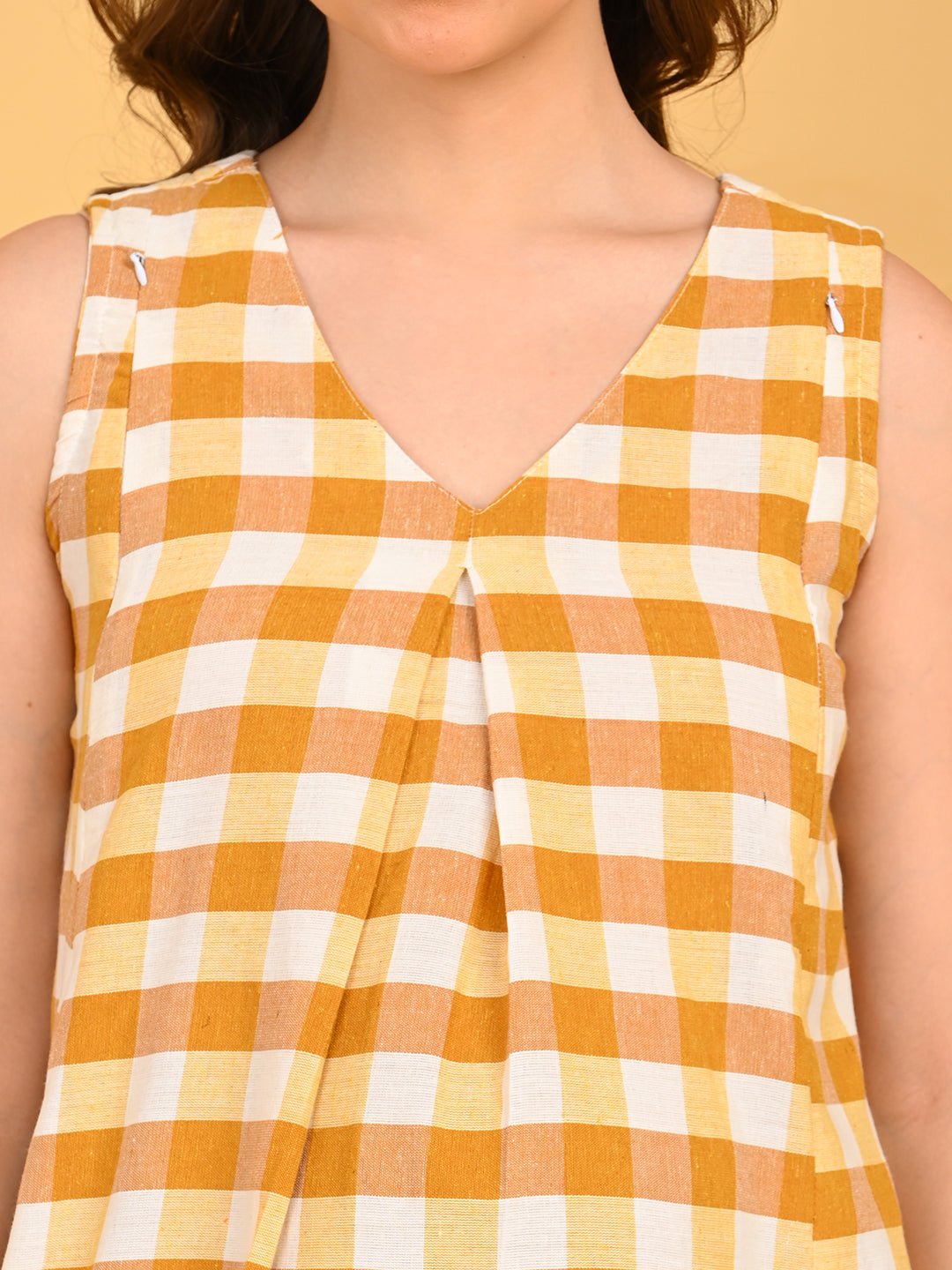 Quiet Grid Maternity and Nursing Shacket Dress close-up of V-neckline and pleated front detail in yellow check fabric.