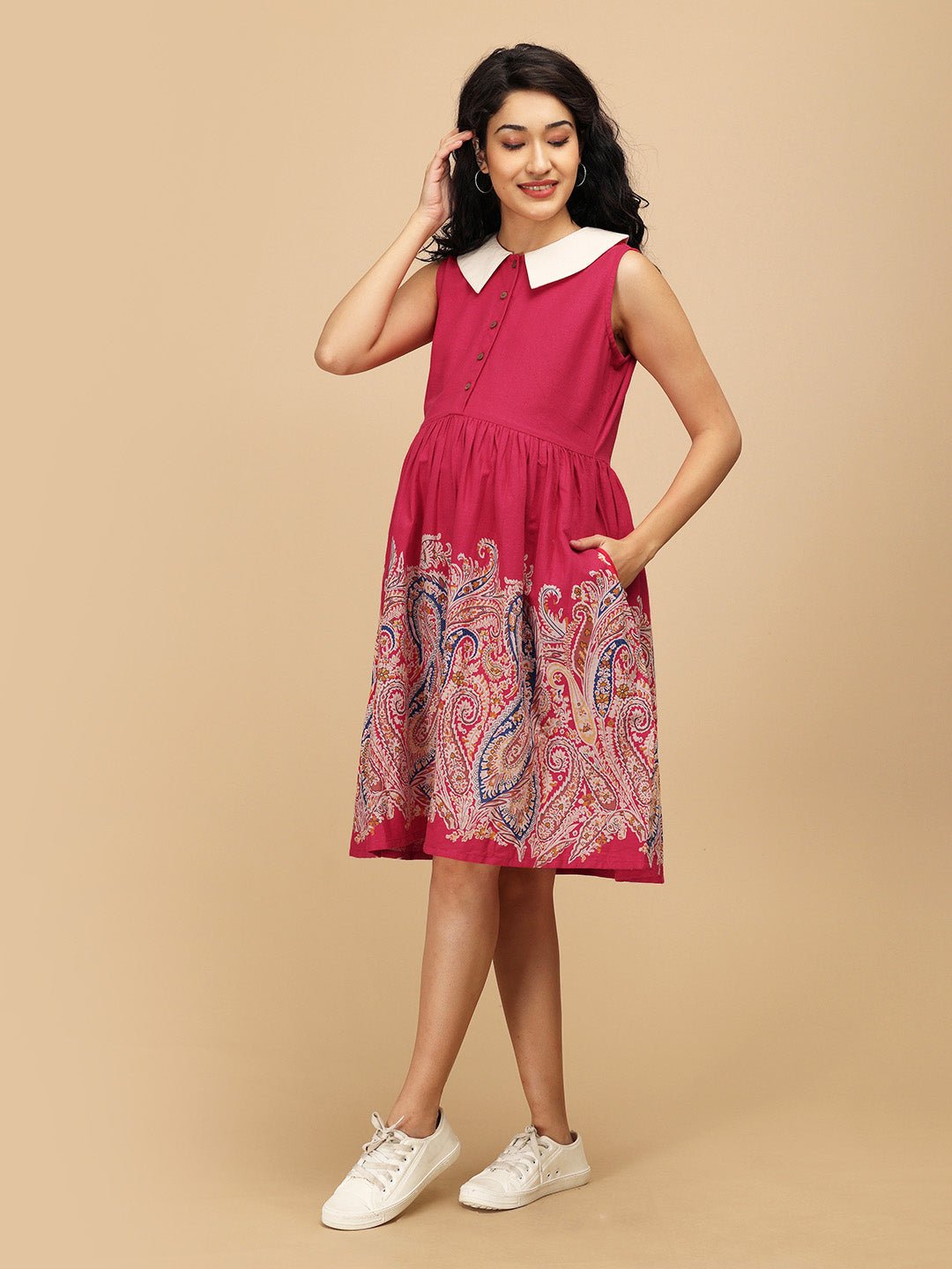 Side view of the Rosé Lane Maternity and Nursing Dress with white collar and paisley border, model holding her baby bump.