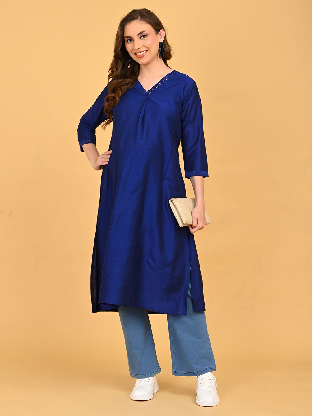 Pregnant model styling royal blue maternity kurta with light blue pants, white sneakers, and beige clutch.