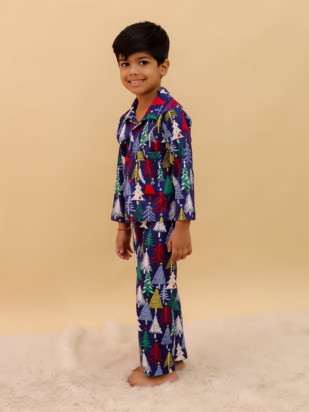 Side view of a smiling boy in The Mom Store Silent Night Christmas Pajama Set, highlighting the relaxed fit and soft cotton texture