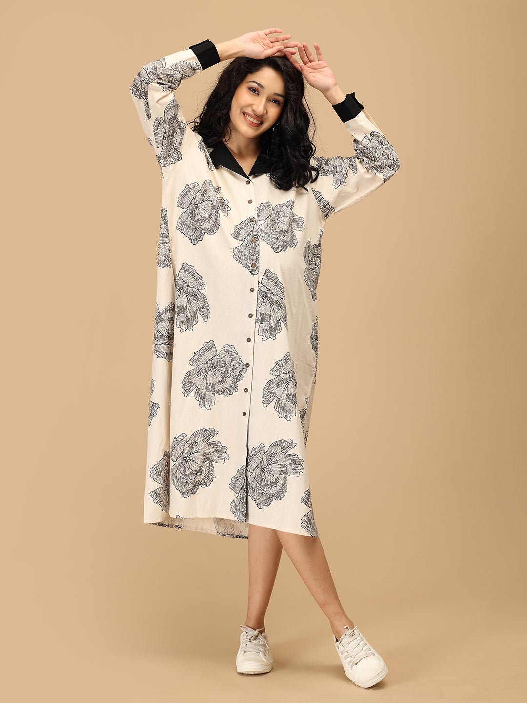 Pregnant woman walking in The Mom Store Sketch Petal maternity dress with black floral design.