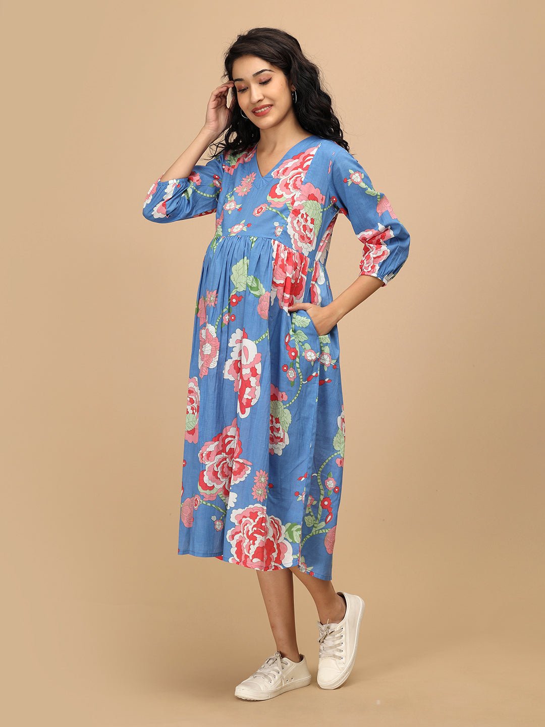 Smiling woman wearing The Mom Store Sky Bloom maternity and nursing dress in blue floral print.