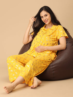 Pregnant model wearing yellow Sparkle Season Maternity and Nursing Nightwear Set from the Mom Store sitting on a bean bag