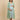 Pregnant model in green striped maternity shacket layered over blue white striped nursing maxi dress, side view.