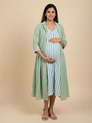 Pregnant model in green striped maternity shacket layered over blue white striped nursing maxi dress, side view.