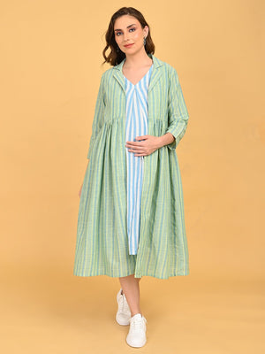 Pregnant model wearing striped maternity dress layered with green striped long shacket, styled with white sneakers.