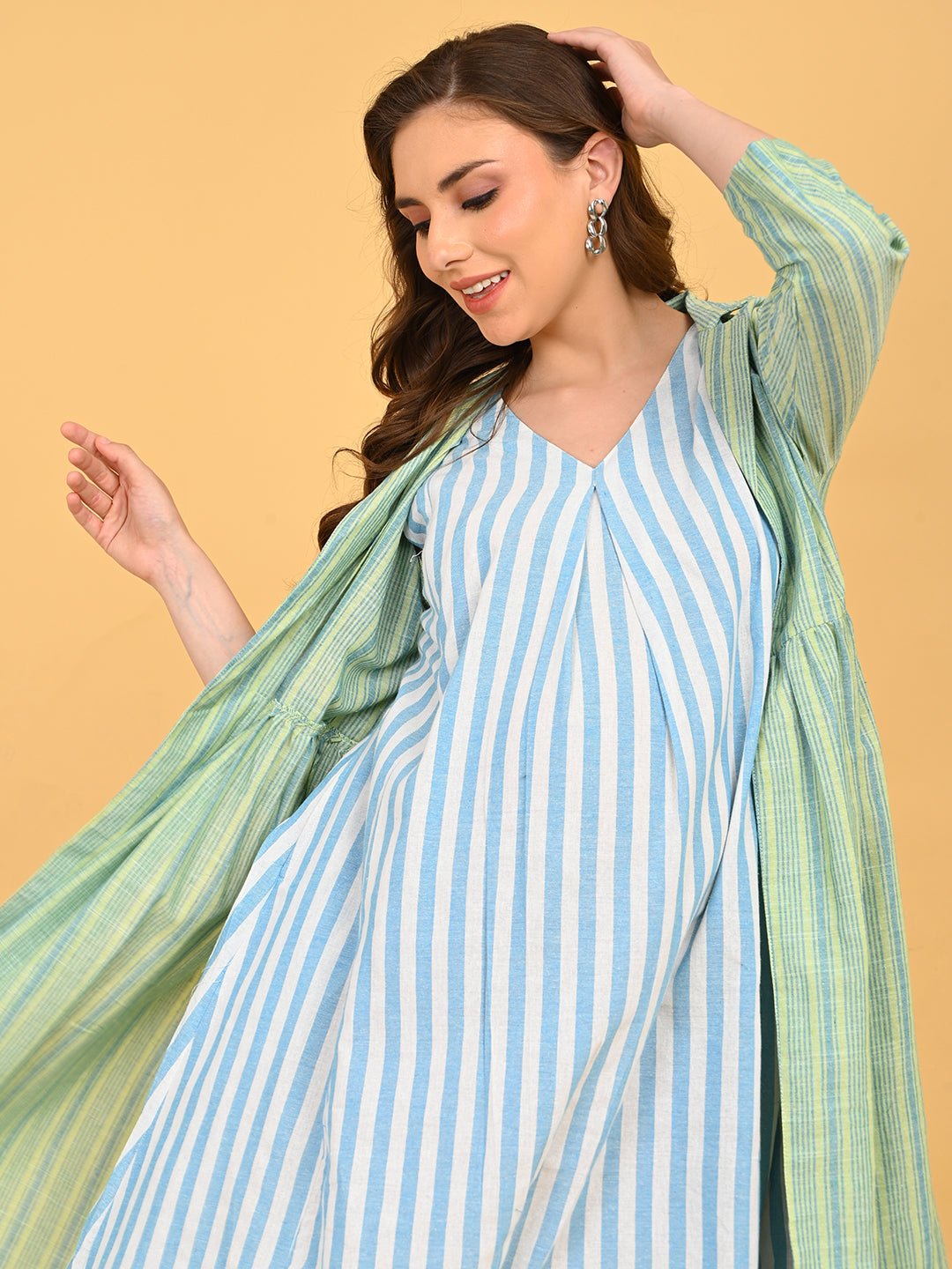 Close-up of Stripe Duet maternity dress under green striped shacket, showing V-neckline and layered look.