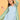 Close-up of Stripe Duet maternity dress under green striped shacket, showing V-neckline and layered look.