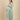 Side pose maternity and nursing outfit with green striped longline shacket over striped maxi dress.