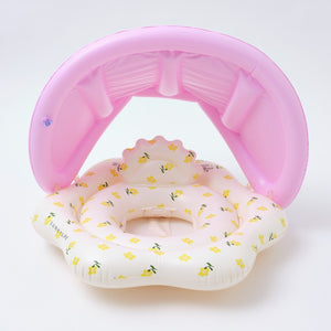 Pink inflatable pool with baby swimming ring on a white background