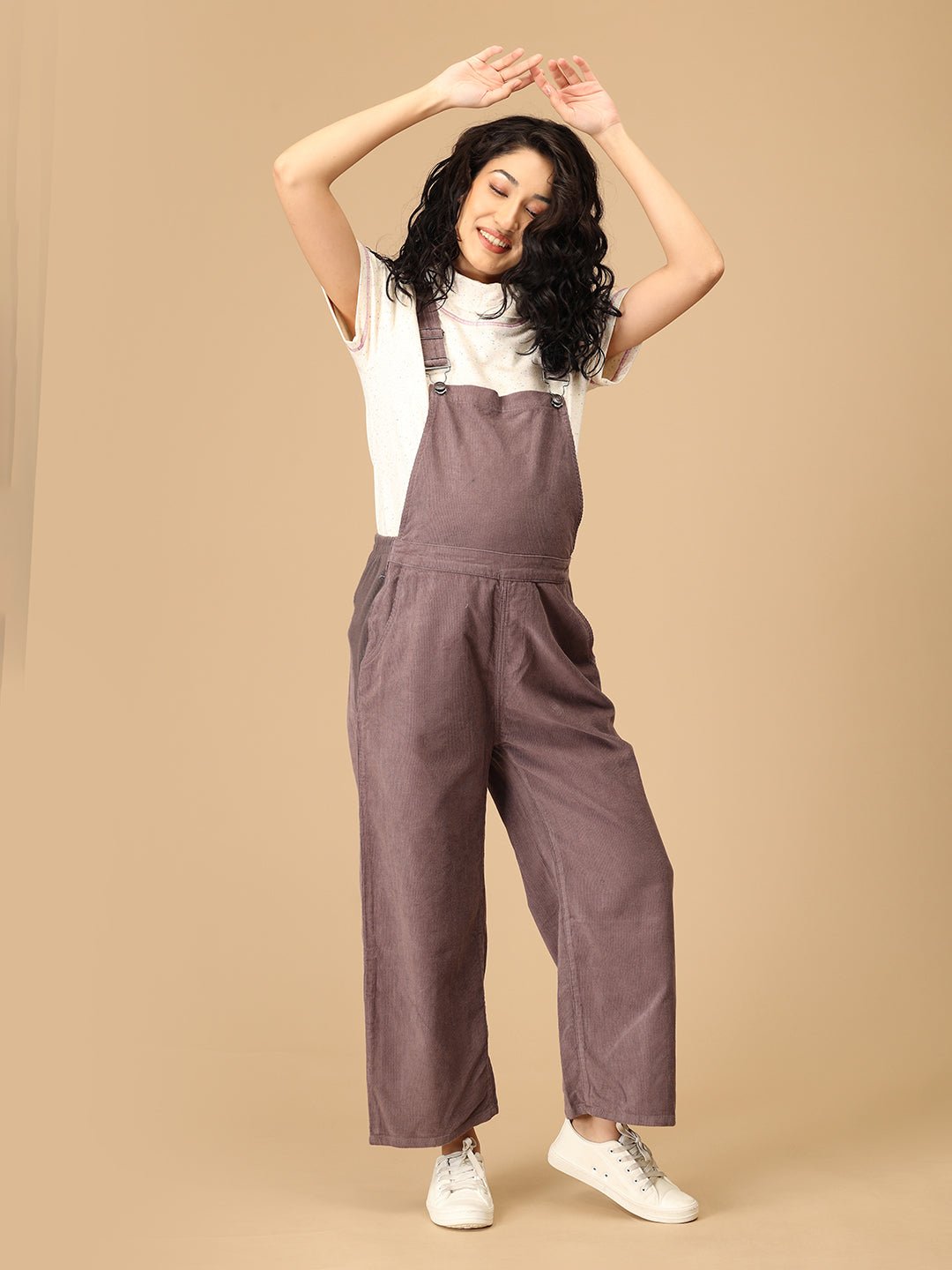 Smiling pregnant woman in The Mom Store taupe corduroy maternity dungaree front view.