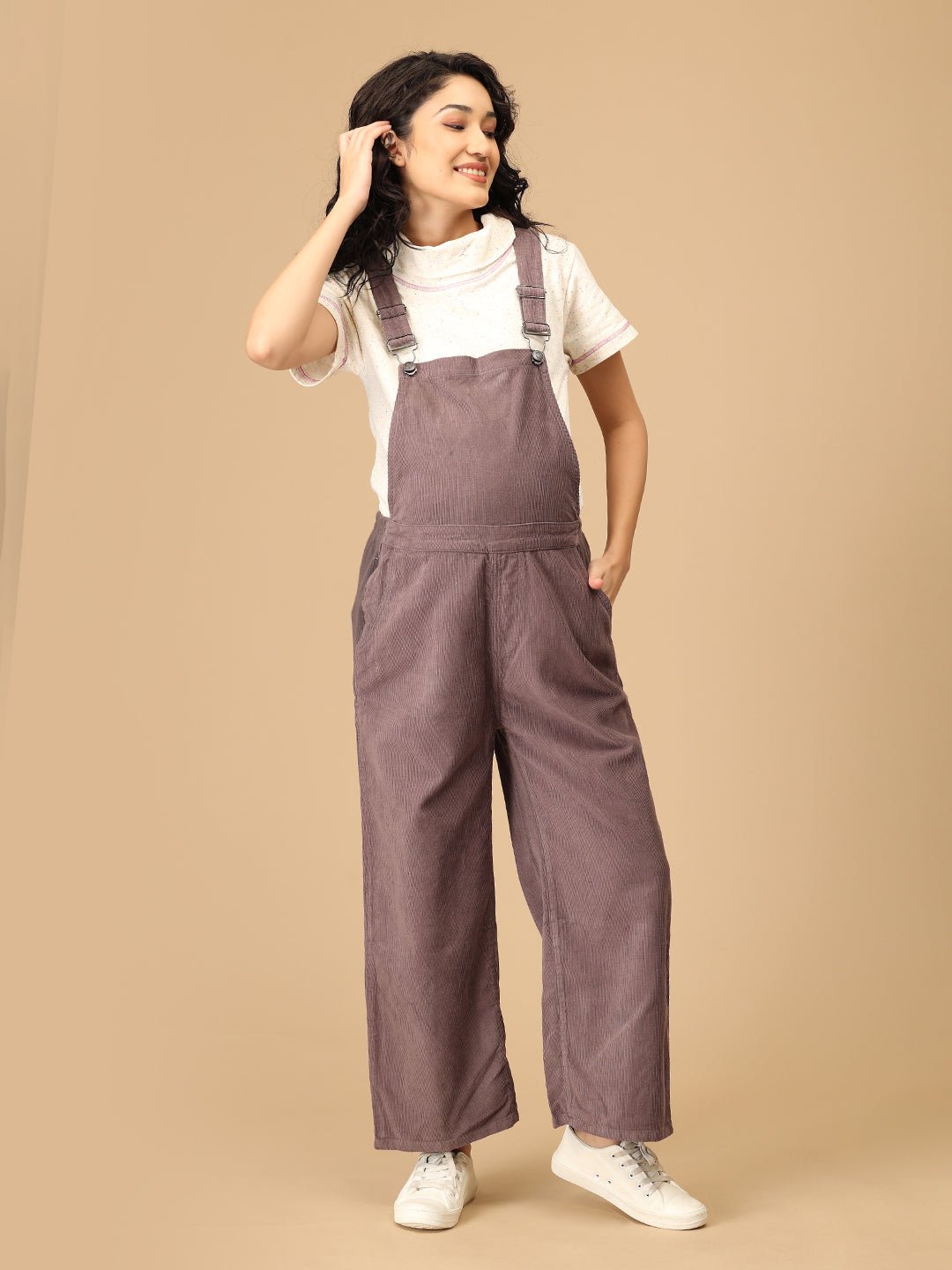Front pose of pregnant woman in The Mom Store taupe corduroy maternity dungaree with pockets.