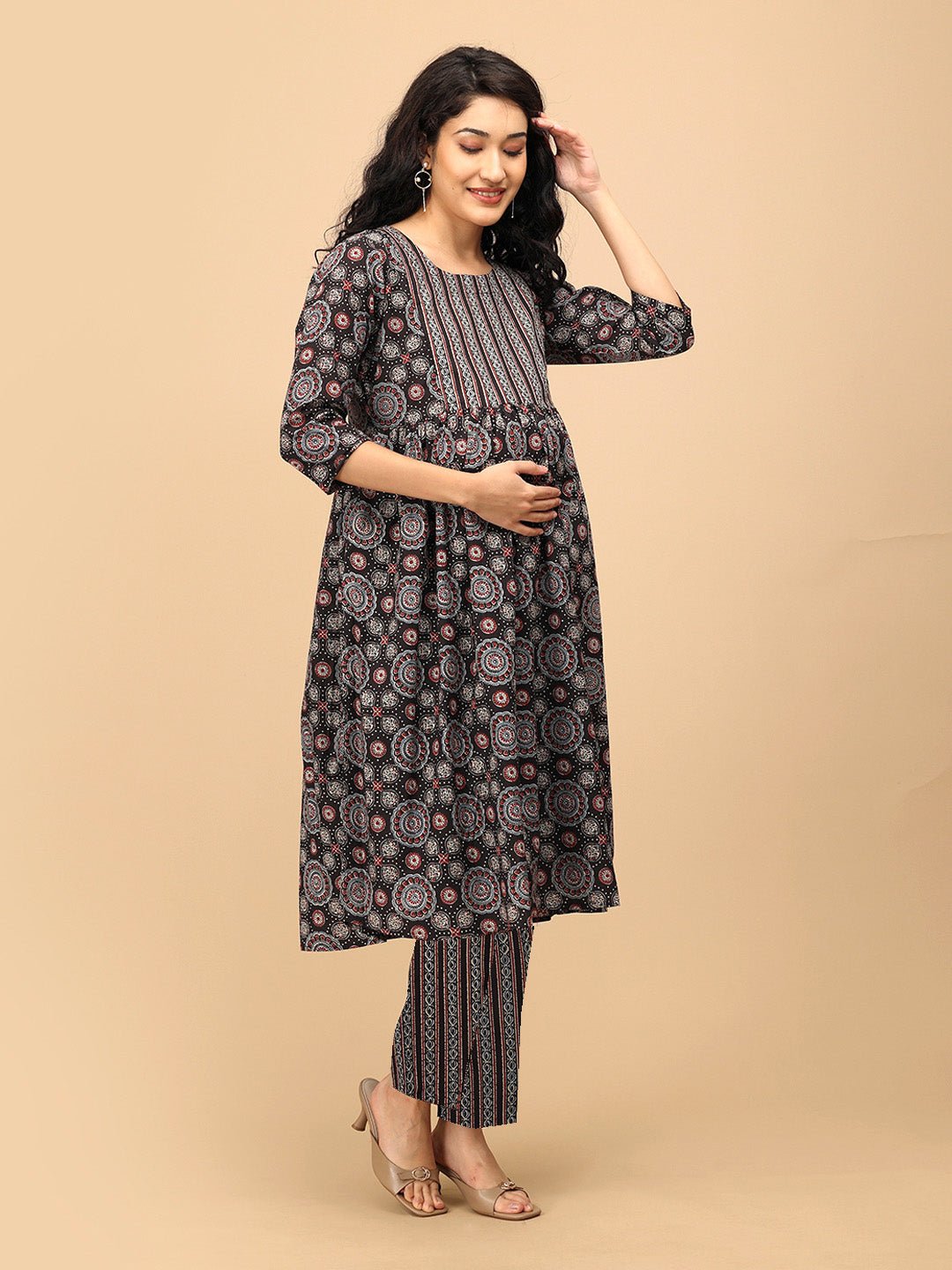 Pregnant woman wearing The Ajrakh Edit black printed maternity and nursing kurta set with straight pants, posing with hand on hair.